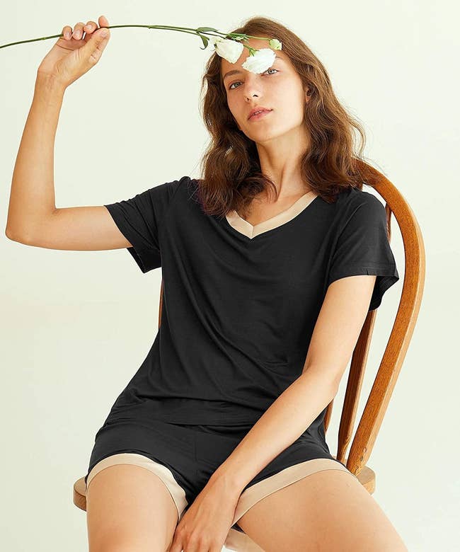 Model wearing black t-shirt and short set with cream trim