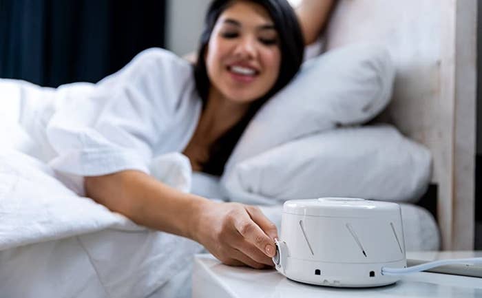 a model in bed turns on their dohm classic