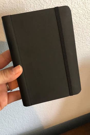 A reviewer's photo which shows the black book is small and discreet