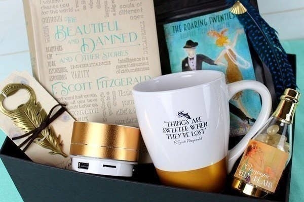 A box filled with a book, a coffee mug, and other bookish items