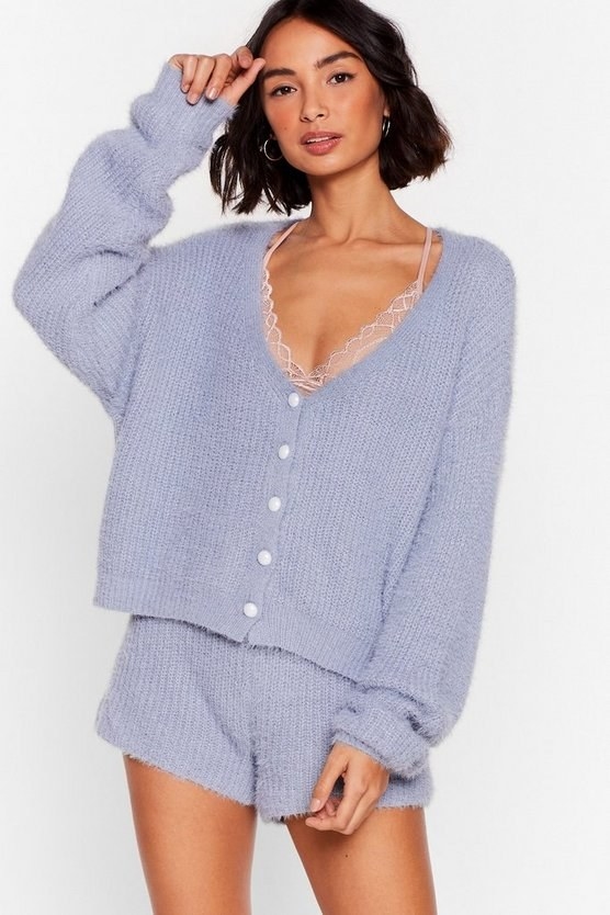 Model wearing lavender colored cardigan with pearls and short set 