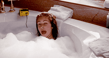 A gif of Julia Roberts in Pretty Woman singing in a foamy bath tub
