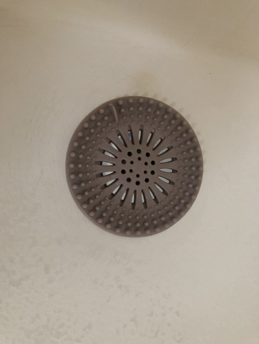 reviewer image of the silicone hair catcher in a bathtub