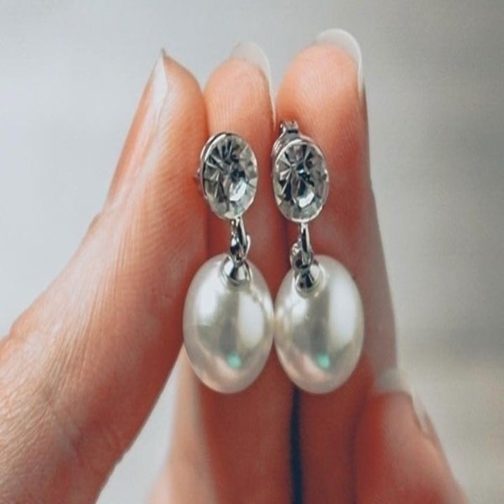 Studded earrings with a pearl attached to the bottom