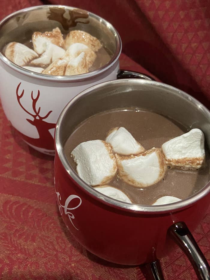 Two cups of hot chocolate with marshmallows inside
