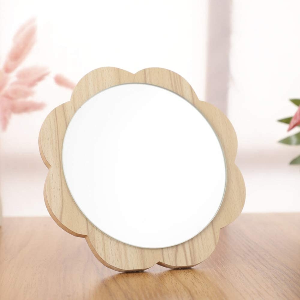 A tabletop mirror with a flower petal shaped rim