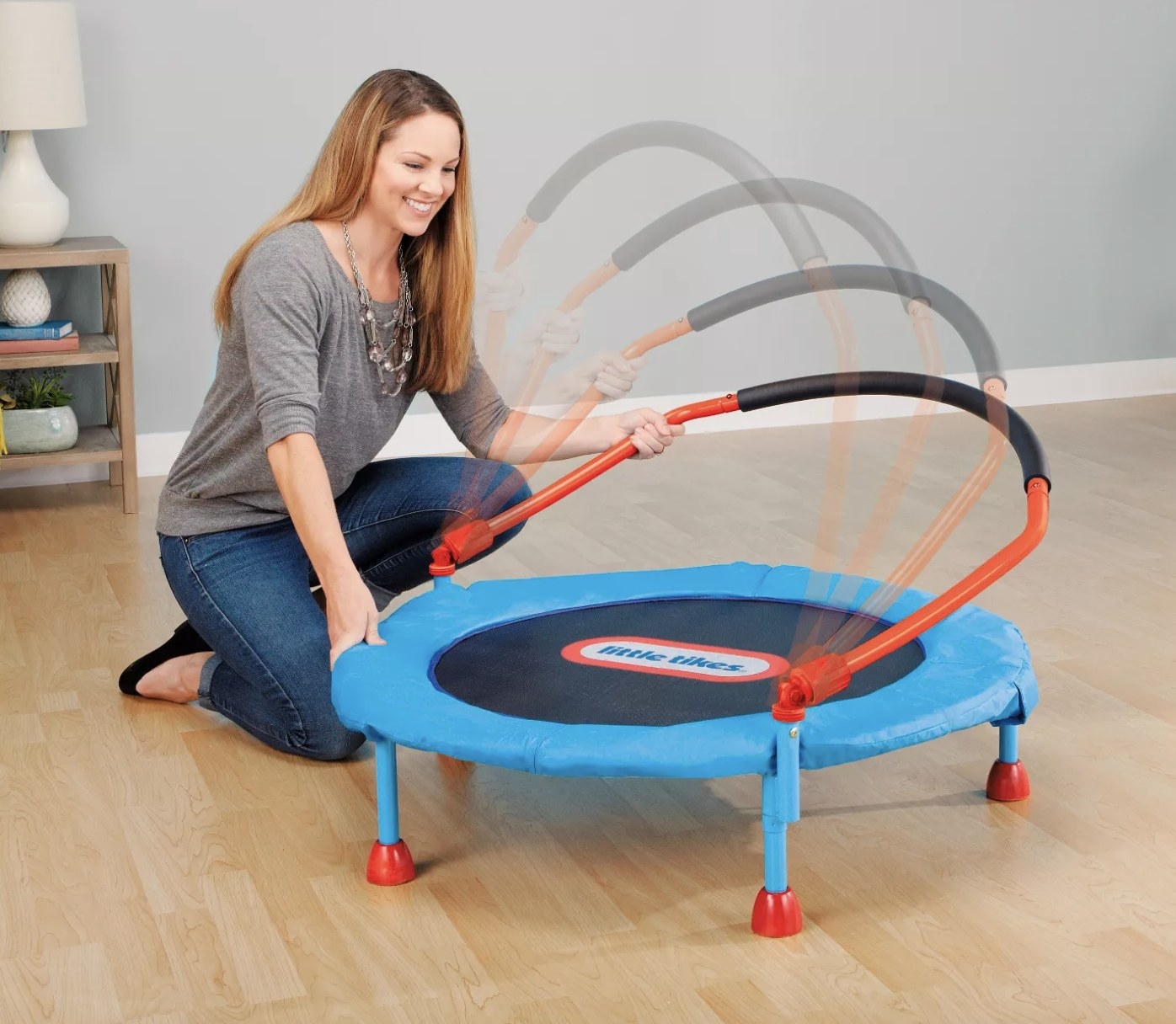 A person setting up a small trampoline