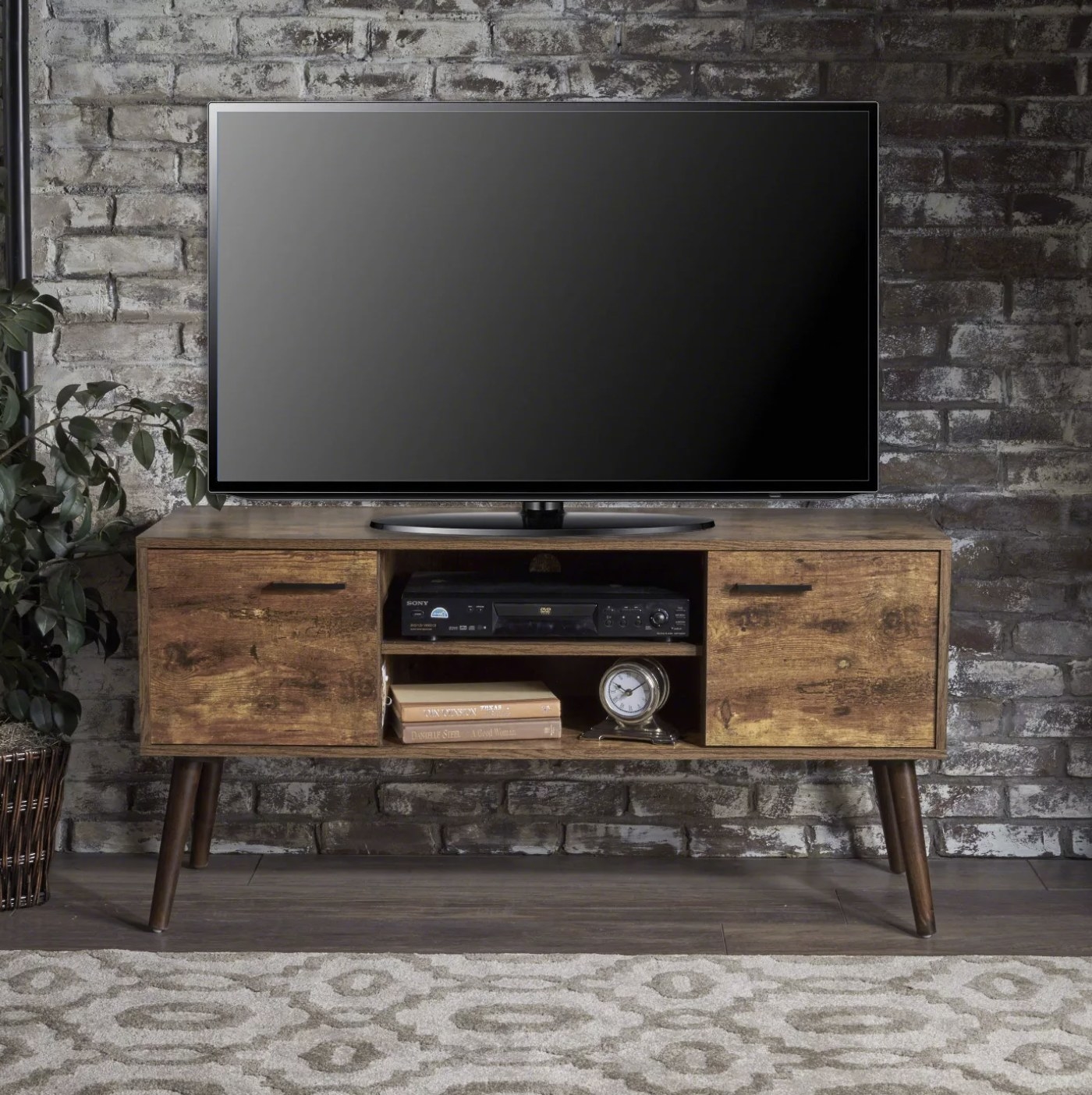 The wood entertainment center with a TV on top