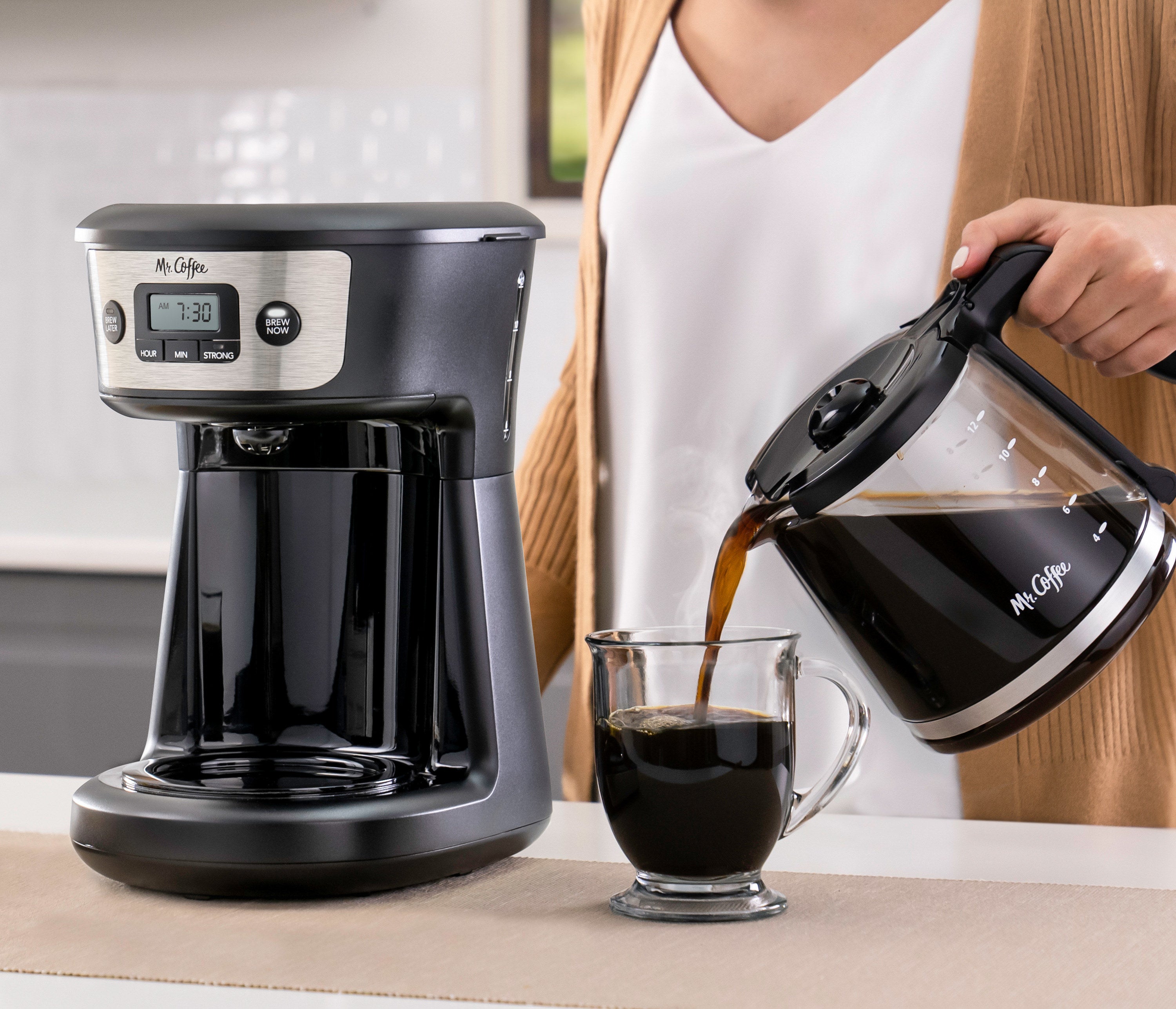 Model pouring coffee from black coffee machine