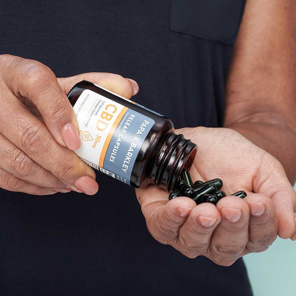 A model pouring capsule Releaf Capsule pills in their hand 