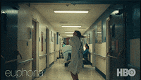 Rue dances down a hospital hallway while wearing a hospital gown. 