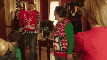 A man shows off an ugly sweater in a Hallmark movie