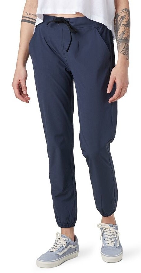 Model wears navy blue soft pants with light blue Vans