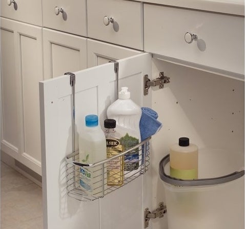 The shelf hung on a cabinet door filled with cleaning supplies