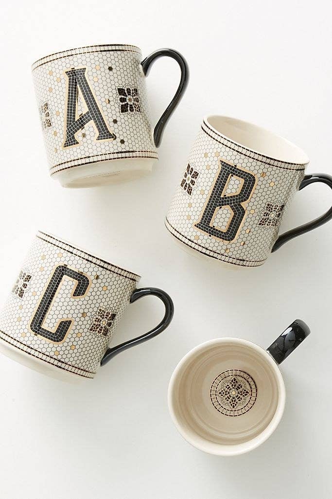 four tiled monogram mugs on a table