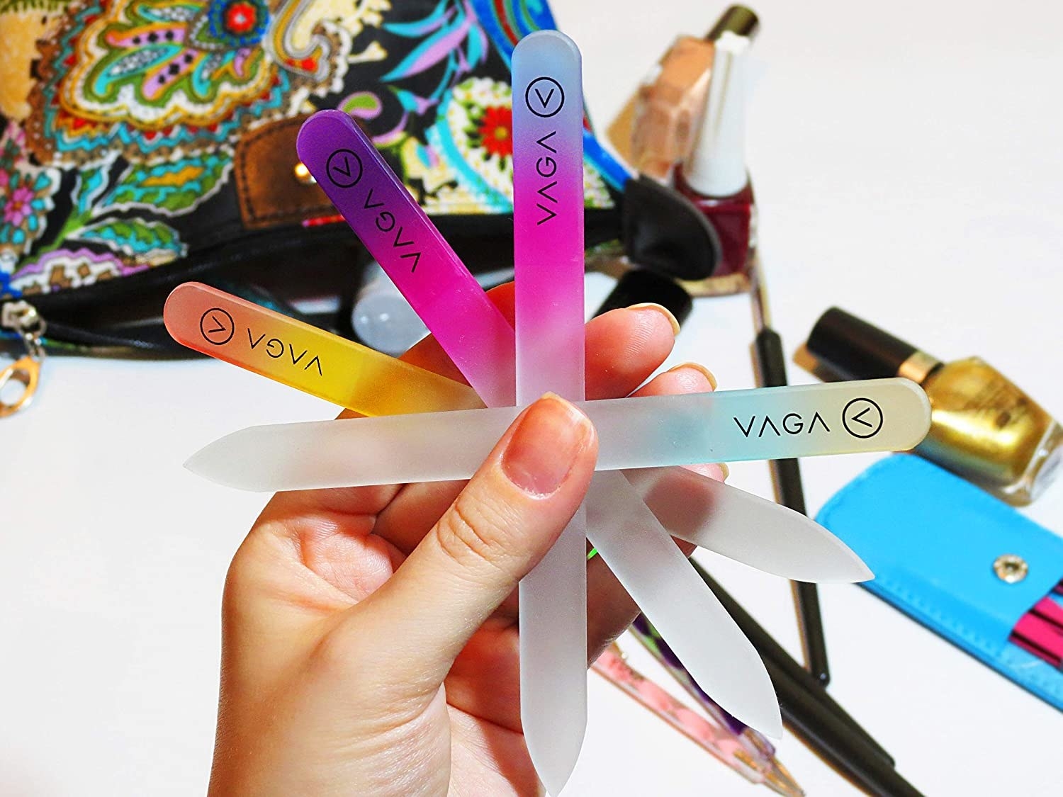 a hand holding four of the nail files which are clear and ombre colored 