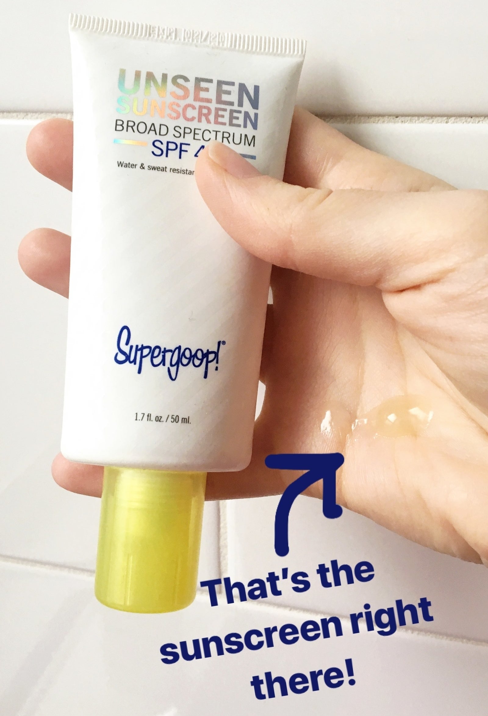 hand holding white bottle of sunscreen with product on hand with text &quot;that&#x27;s the sunscreen on hand&quot; 