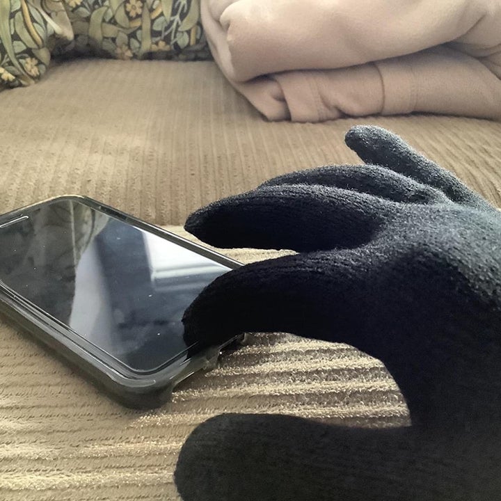 reviewer photo demonstrating that you can use the screen on your smartphone while wearing the glove