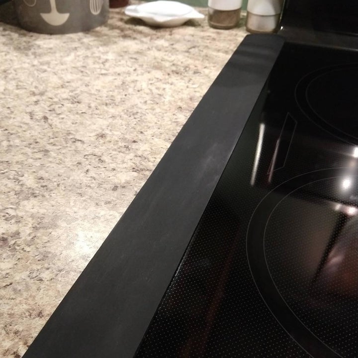 same reviewer showing their gap covers laying flat and creating a seamless cover between their counter and stovetop