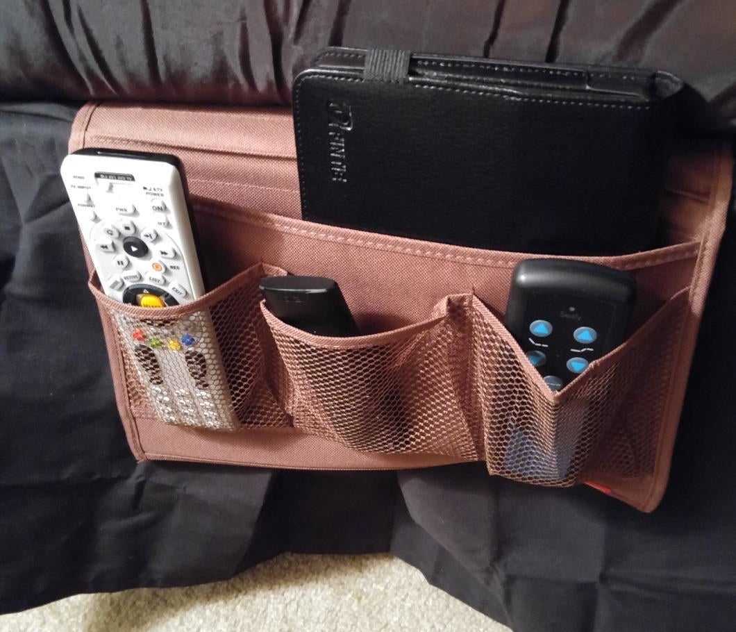 reviewer photo showing bedside caddy with remotes and a book in it 