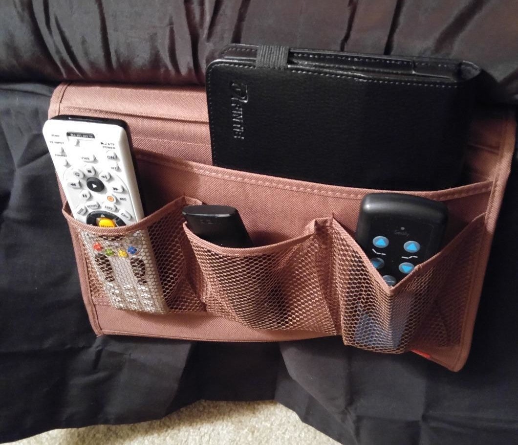 reviewer photo showing bedside caddy with remotes and a book in it 