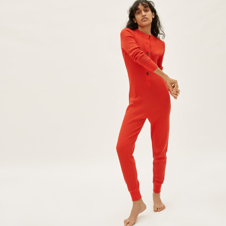 Model wearing red-orange waffle-knit onesie