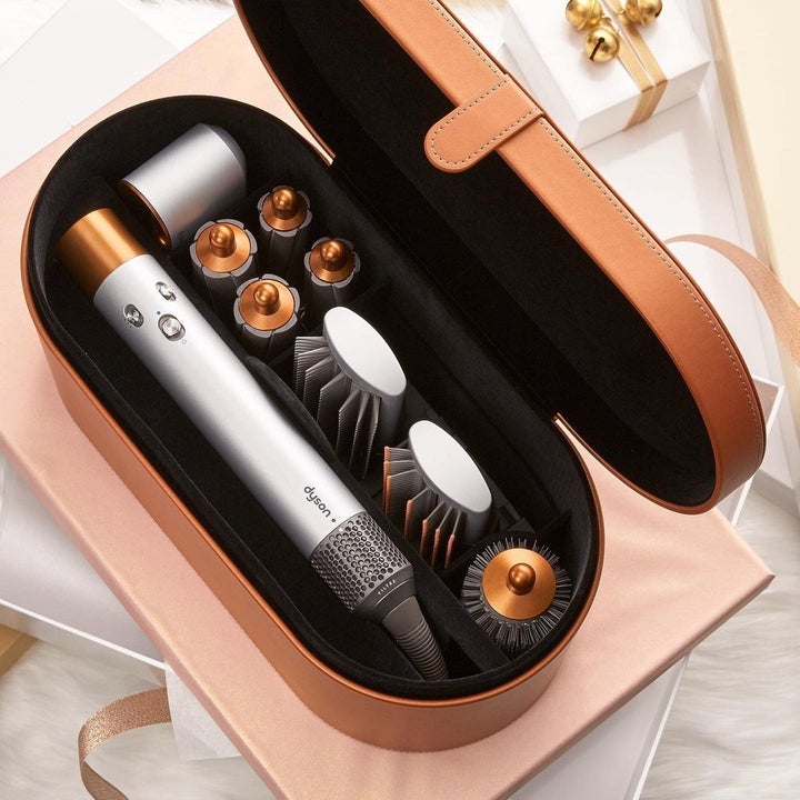 the air warp with three brush attachments and four curling attachments and a blow dry attachment in a rose gold case