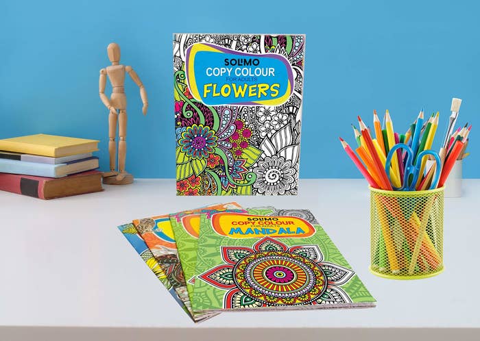 Colouring book set on a table with art supplies