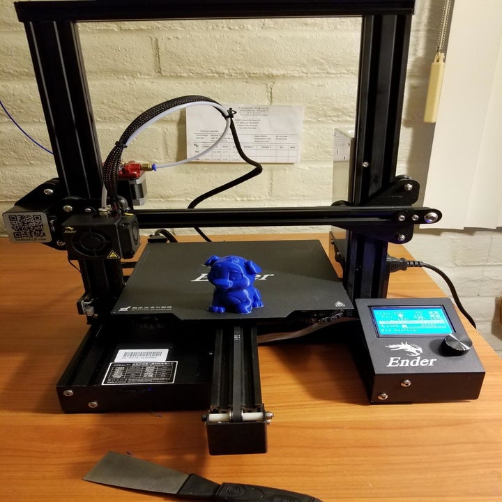 the machine making a 3d printed blue dog