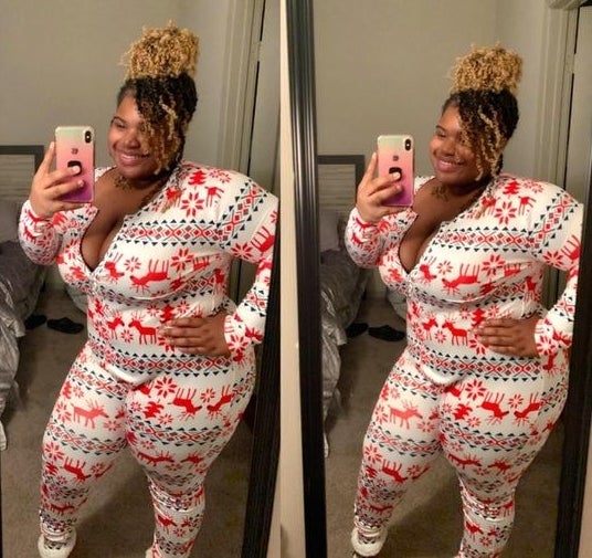 Reviewer wearing the onesie in a red and white holiday pattern 