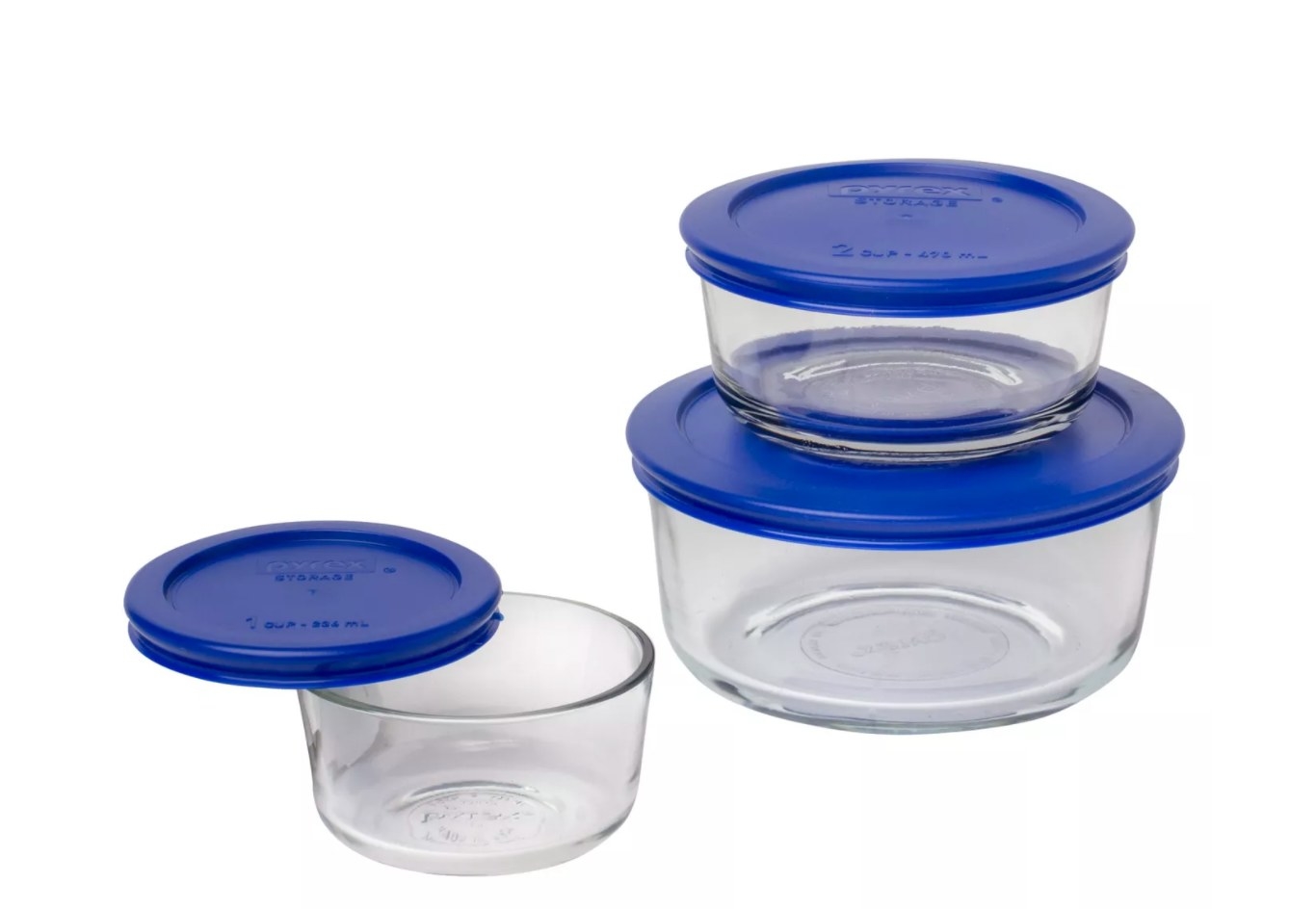 A set of three glass food storage containers with blue tops.