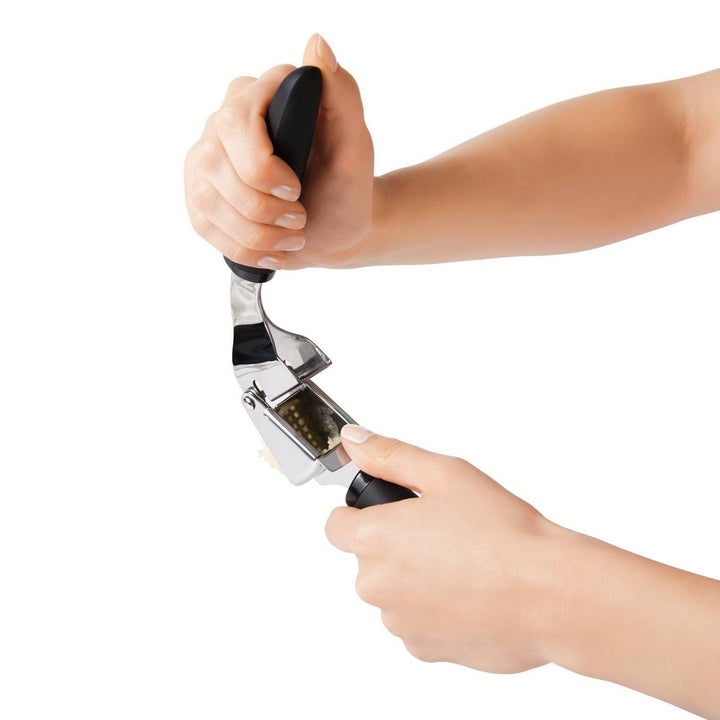 person moving handles of garlic press