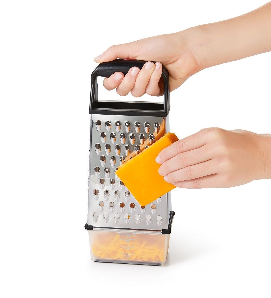 block of cheese being grated on a box grater and the cheese being caught on the bottom