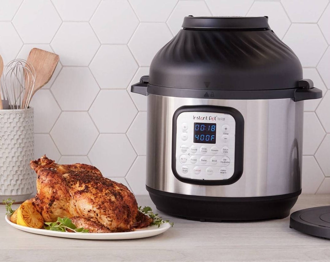 Instant pot with air fryer lid and a cooked chicken next to it