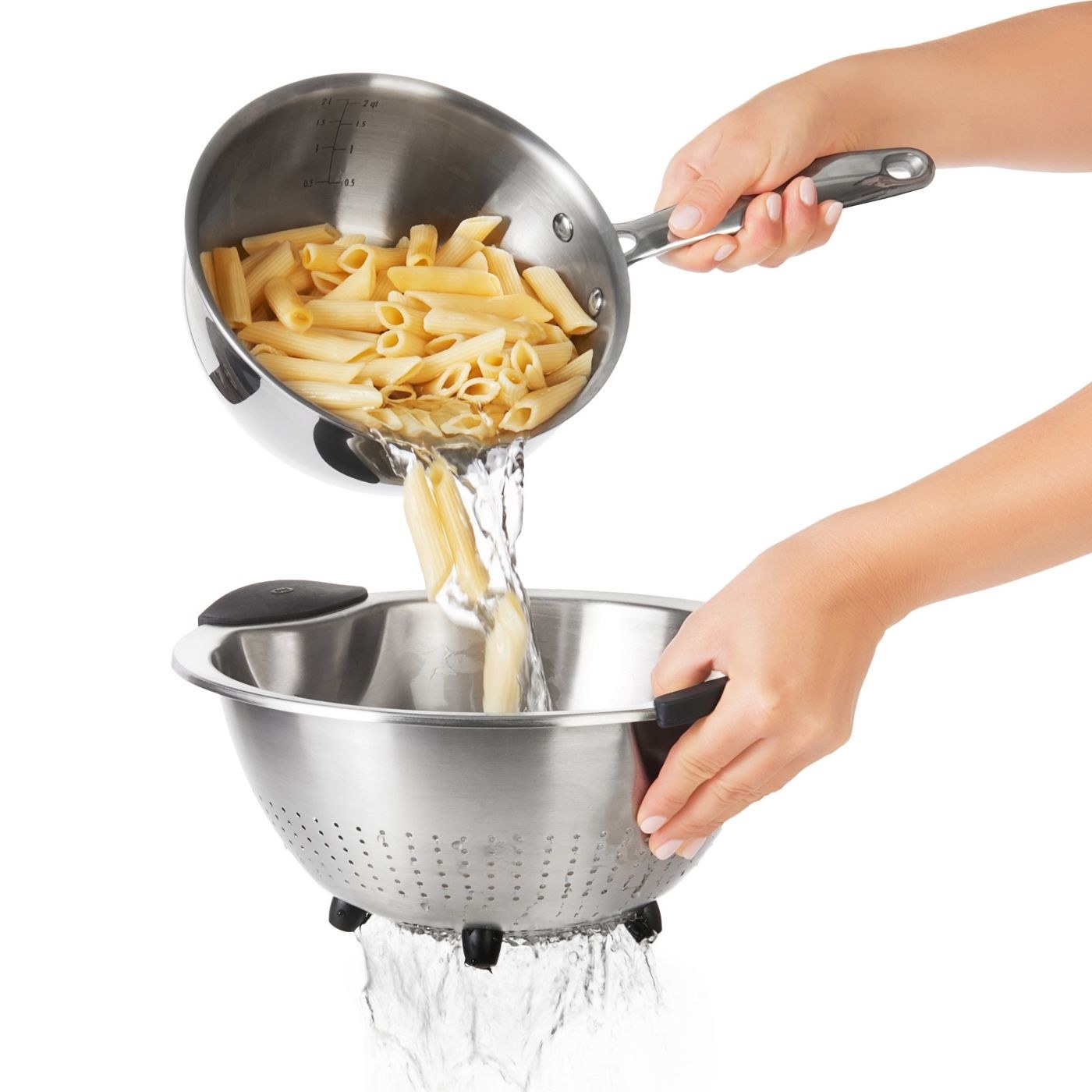 person draining pasta in a stainless steel colander