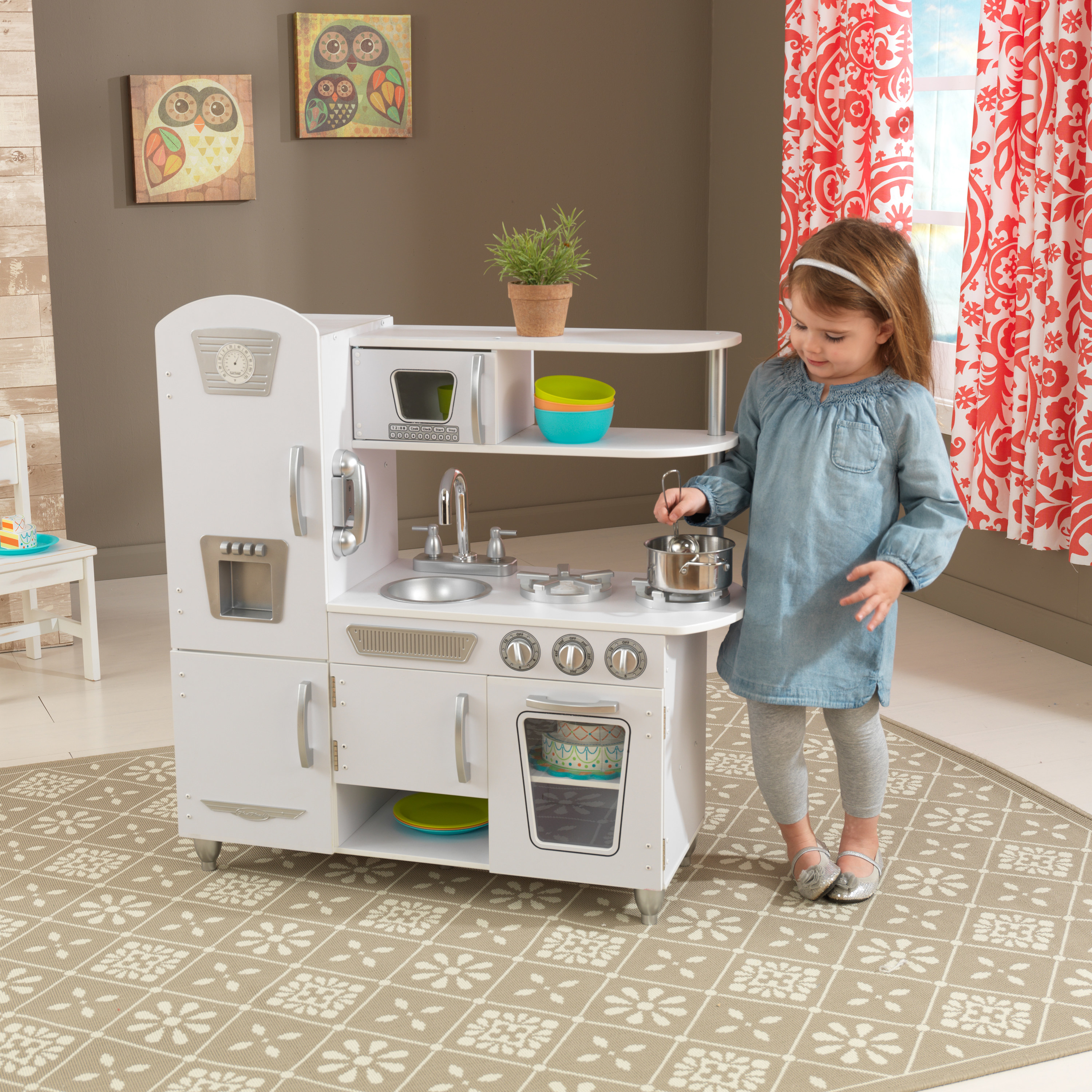 A child playing with the white kitchen