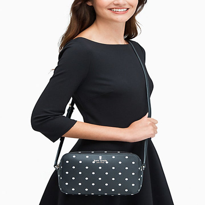 Model carrying rectangular medium crossbodybag in black with white polka dots