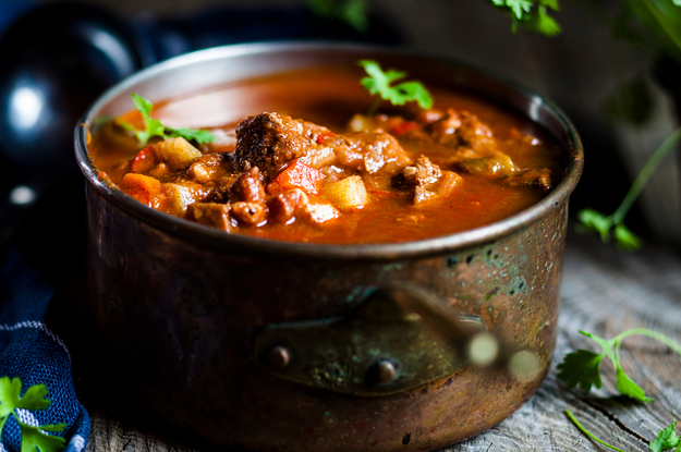 pot of soup with beef potatoes and parsley