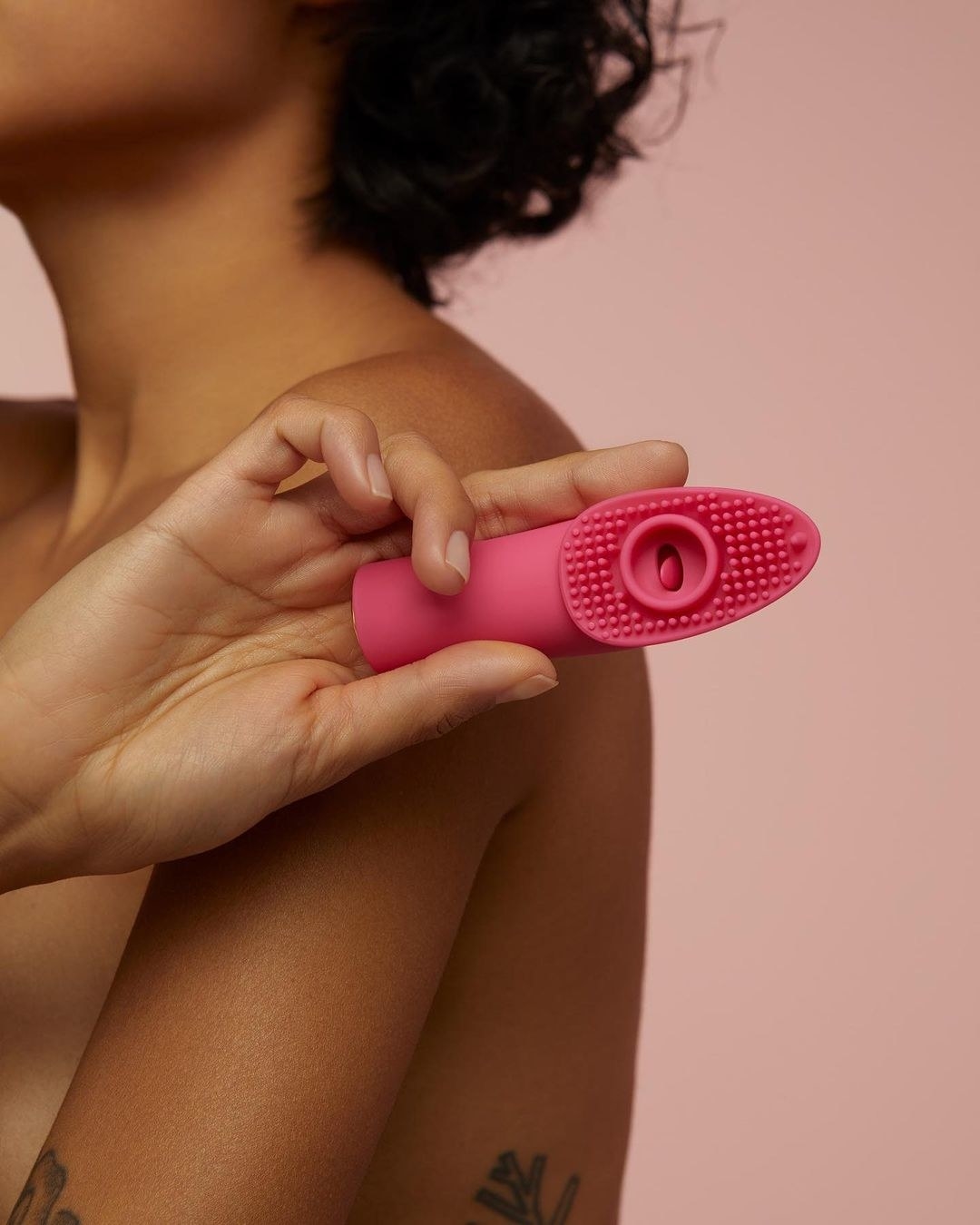 A model holding the vibrator and showing off its 105 textured rods