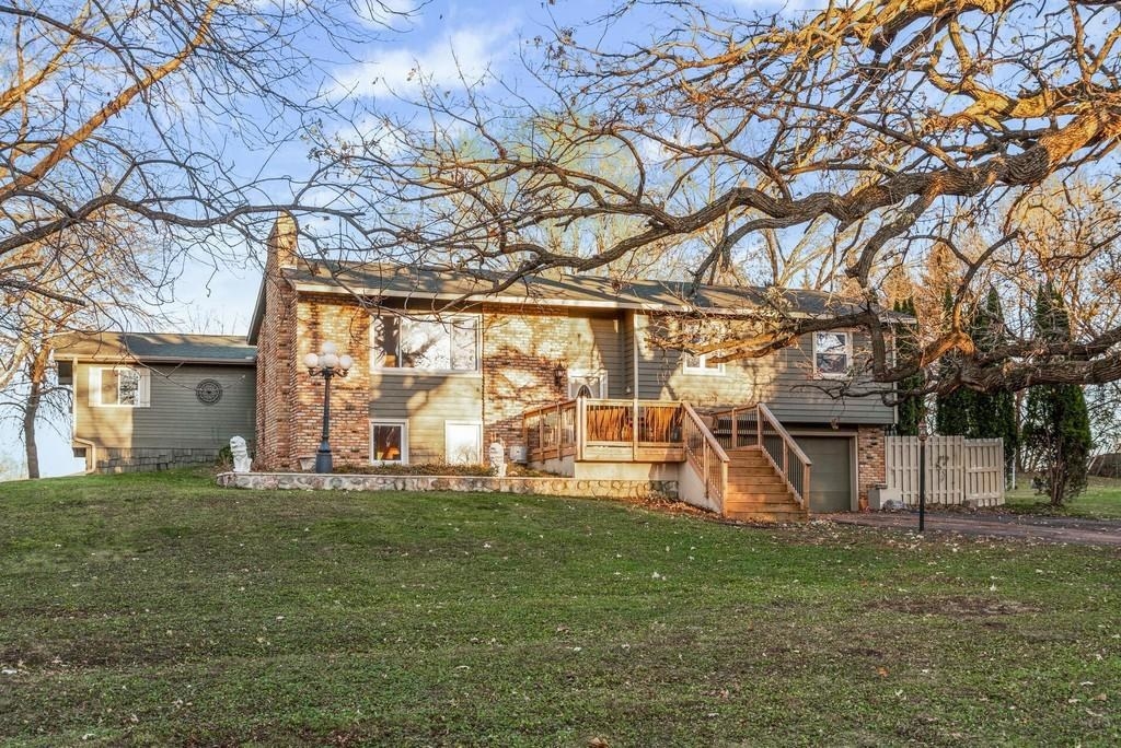 Two story home with a big tree and lawn in front