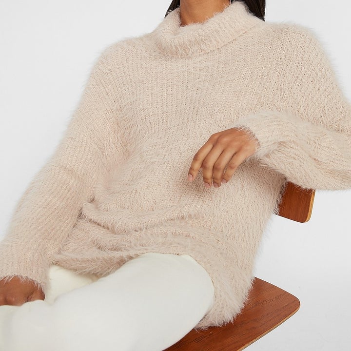 model in fuzzy off-white turtleneck sweater