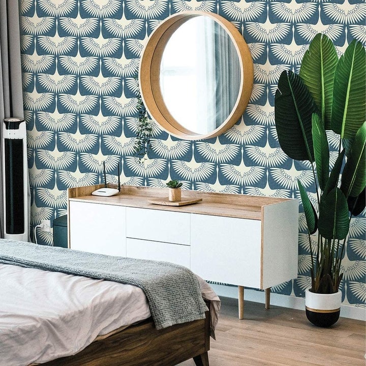 the same print wallpaper in teal on a bedroom wall