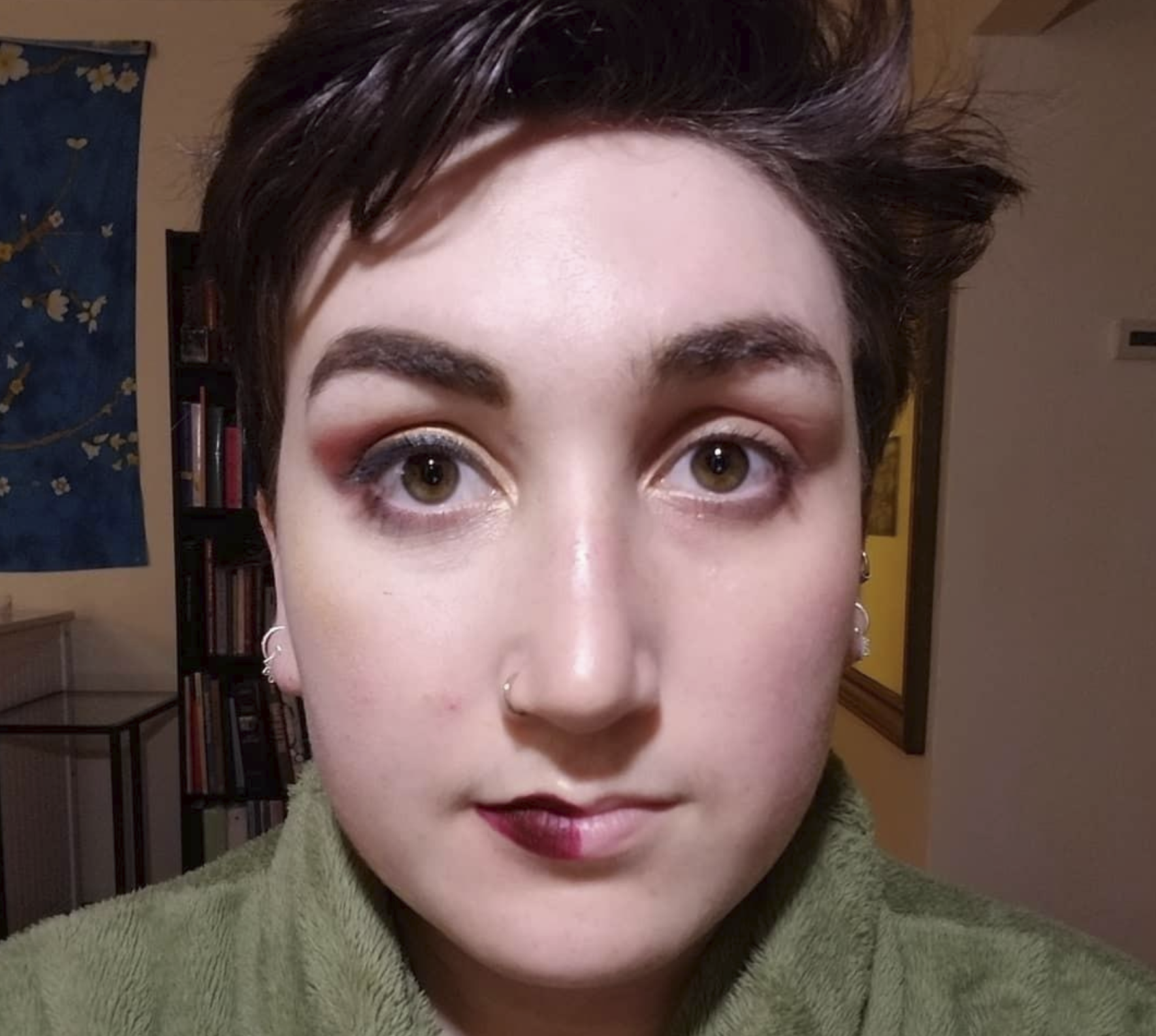 reviewer with half their face full of makeup and the other half with no makeup after it's been taken off by the cloths