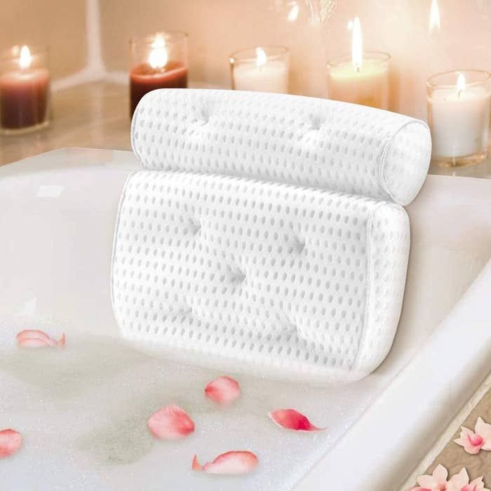 bath pillow on the bath tub surrounded by candles