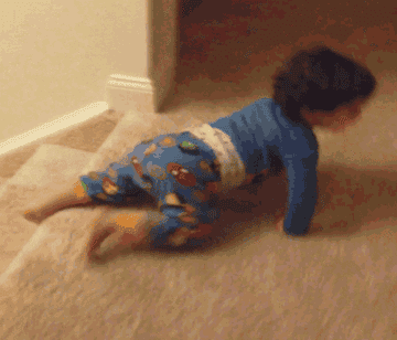 A toddler slides down a carpeted staircase on his belly