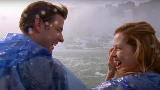 Jim and Pam smiling at one another under the spray of Niagara Falls