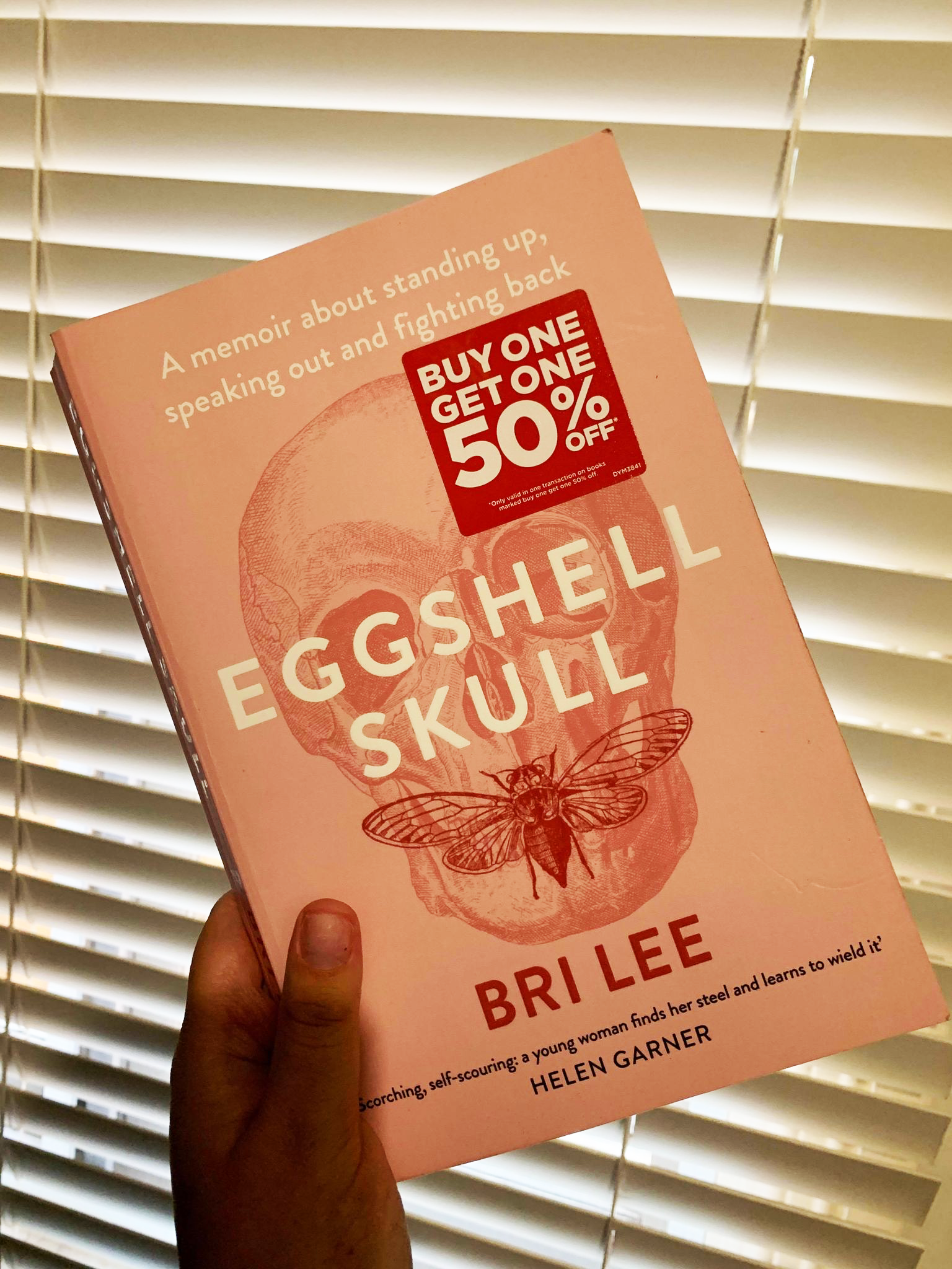 Book cover shows a faint etching of a skull with a winged insect stretching across the mouth