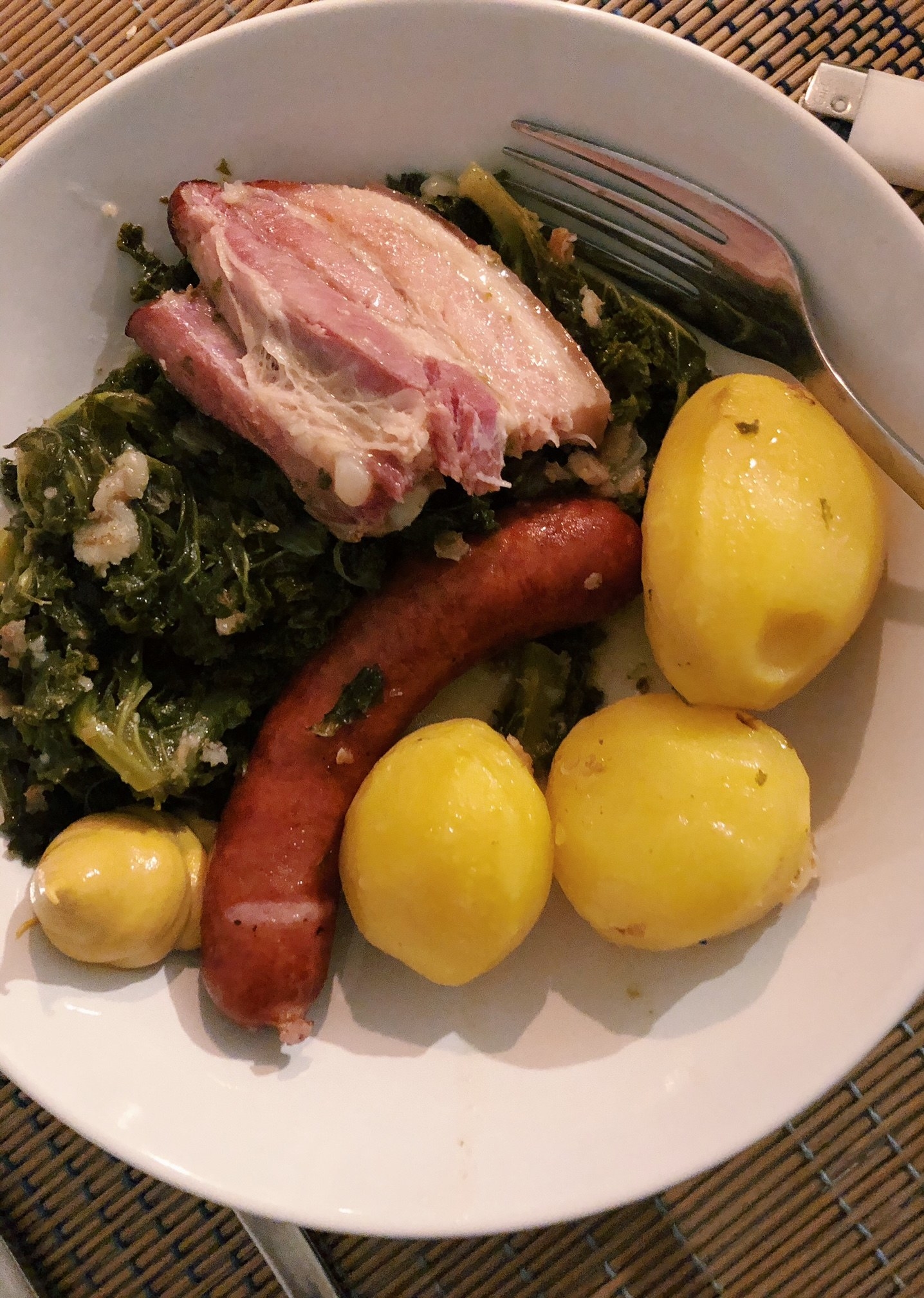 Homemade German kale stew with smoked sausage and boiled potatoes