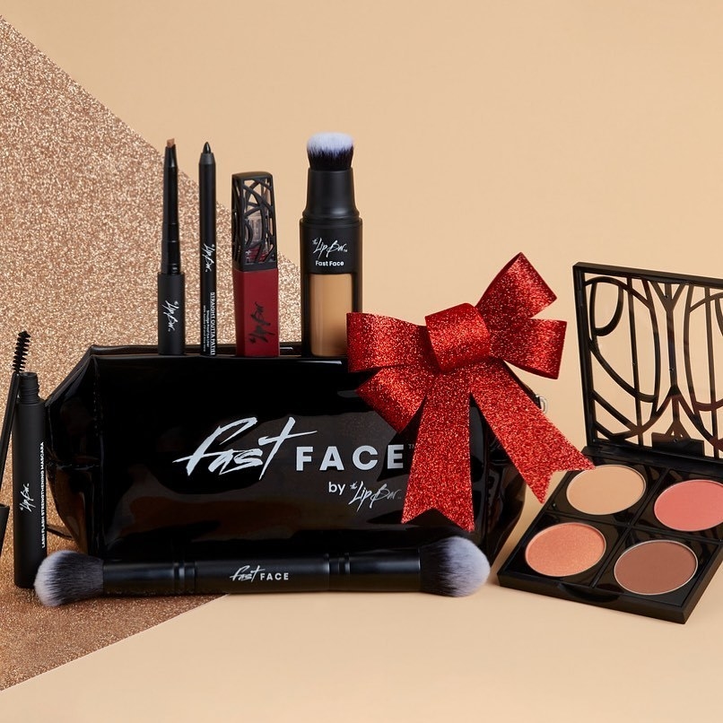 the lip bar's fast face kit with lip, eye, and face products and a case, all with a red bow