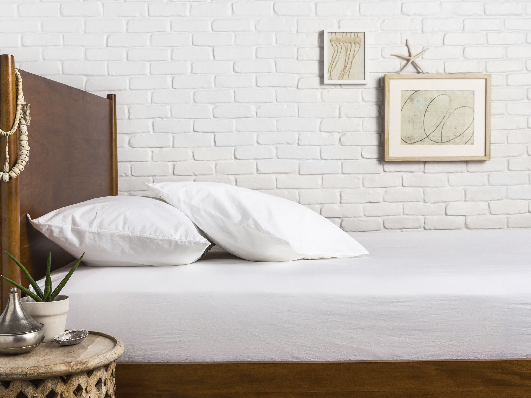 a bed with white sheets and pillows